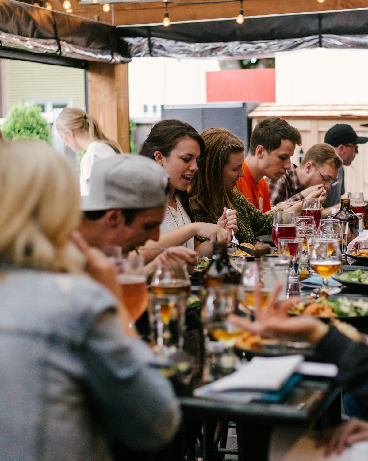 A long communal table of people sharing a meal and conversation.