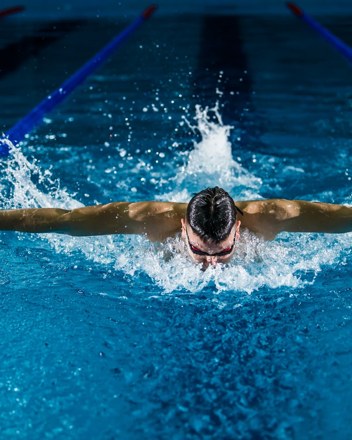 A swimmer mid-stroke in a training pool.
